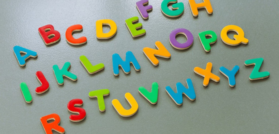 tabletop composition - colourful magnet letters form the abc / Alphabet on a grey metal background